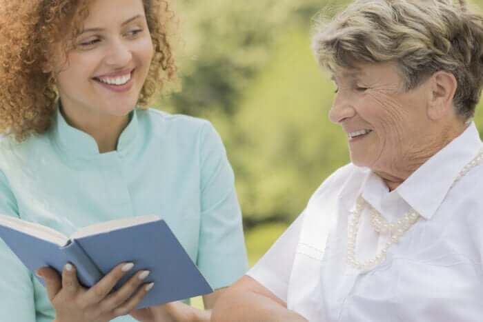 Rentnerin geniesst das gemeinsame Lesen mit ihrer Betreuerin, wodurch Angehörige notwendige Entlastung erhalten.