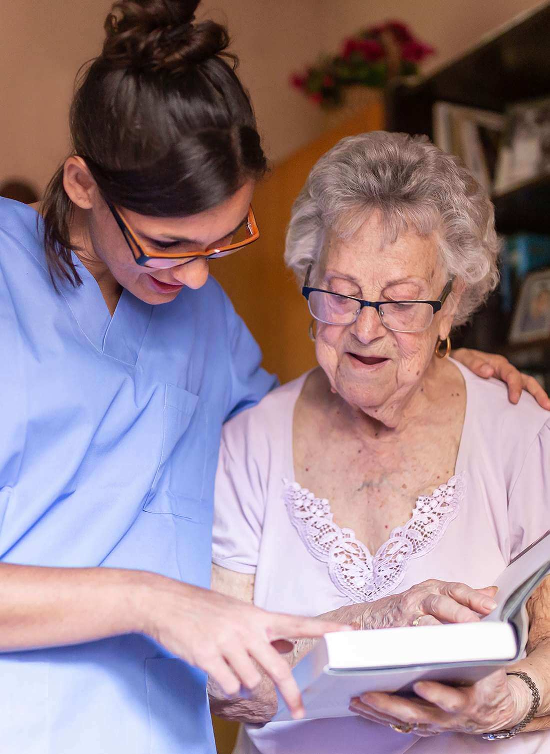Glückliche Rentnerin mit ihrer Betreuerin zuhause in Gösgen im Gespräch über ein Buch.