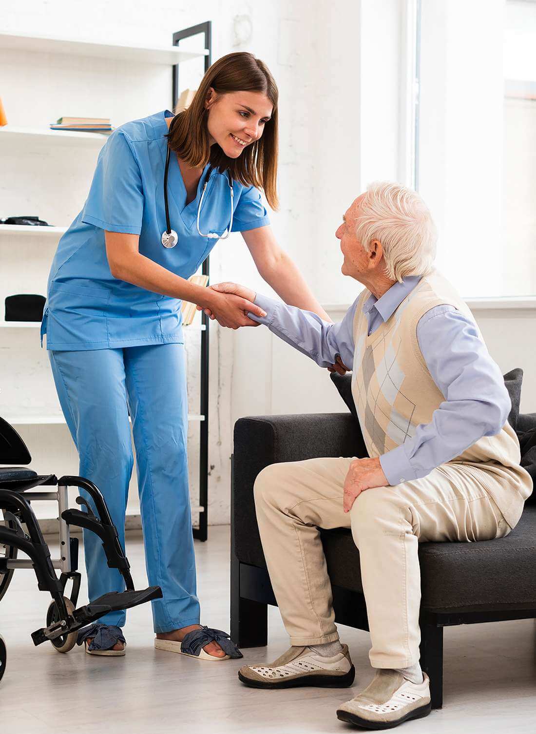 Eine Pflegende der Spitex Laufen hilft einem älteren Herr kompetent vom Sofa in den Rollstuhl.