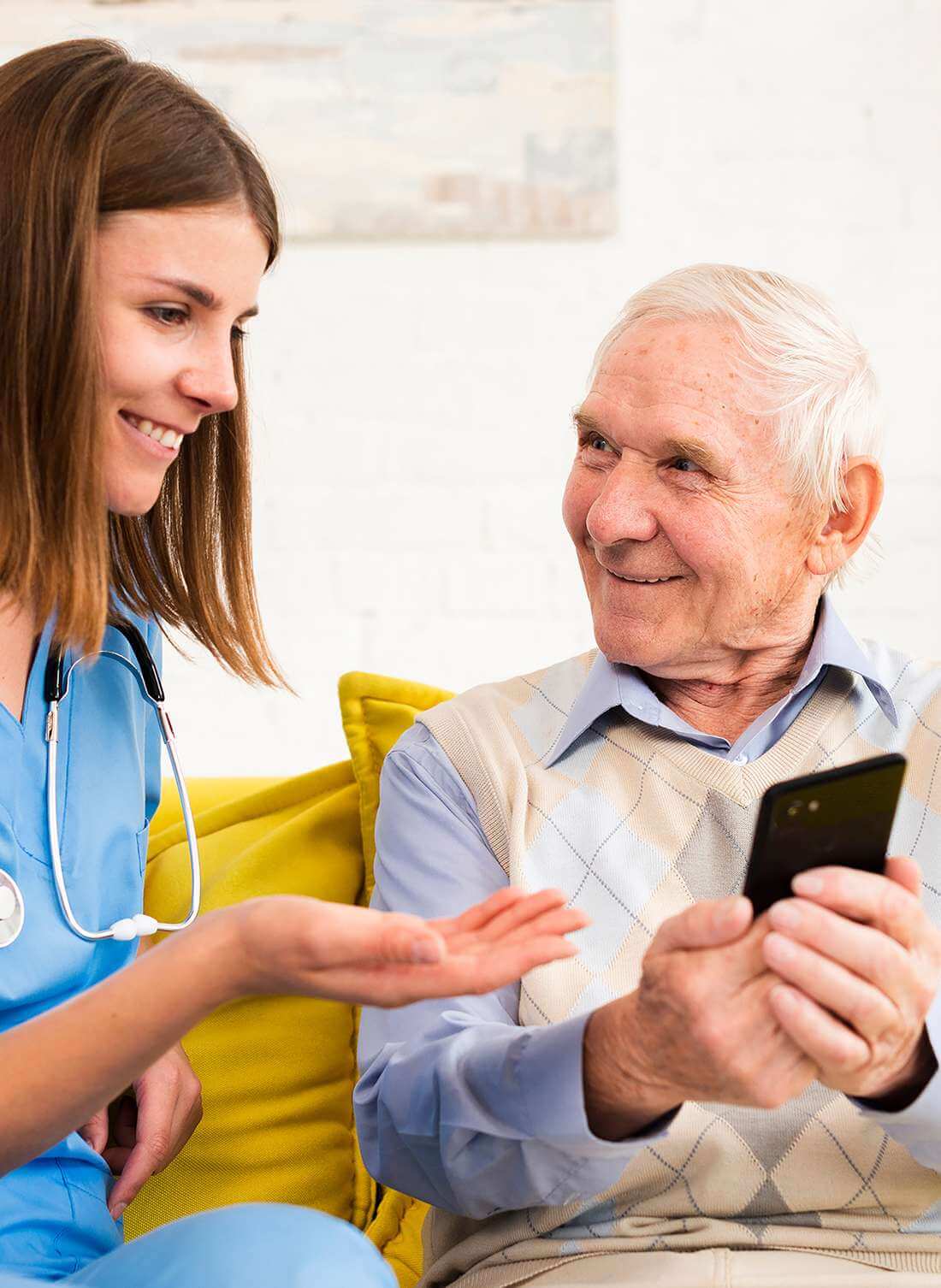 Eine Mitarbeitende der Spitex Laufenburg erläutert dem interessierten Rentner die Bedienung seines Smartphones.