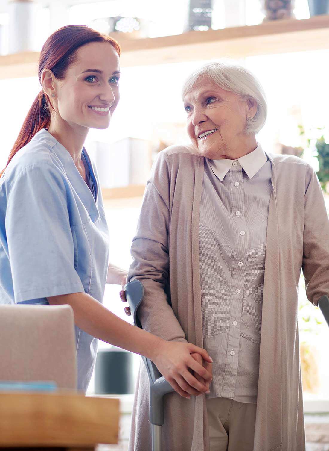 Rentnerin mit Krücken lächelt im Gespräch mit einer Pflegekraft der Spitex Thierstein.